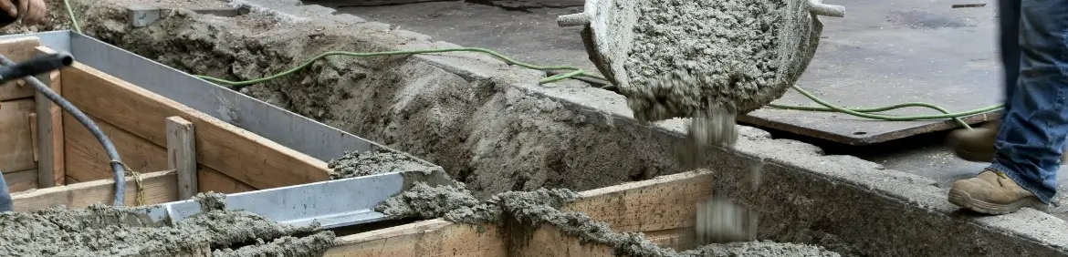 Mężczyzna wylewający beton na fundament